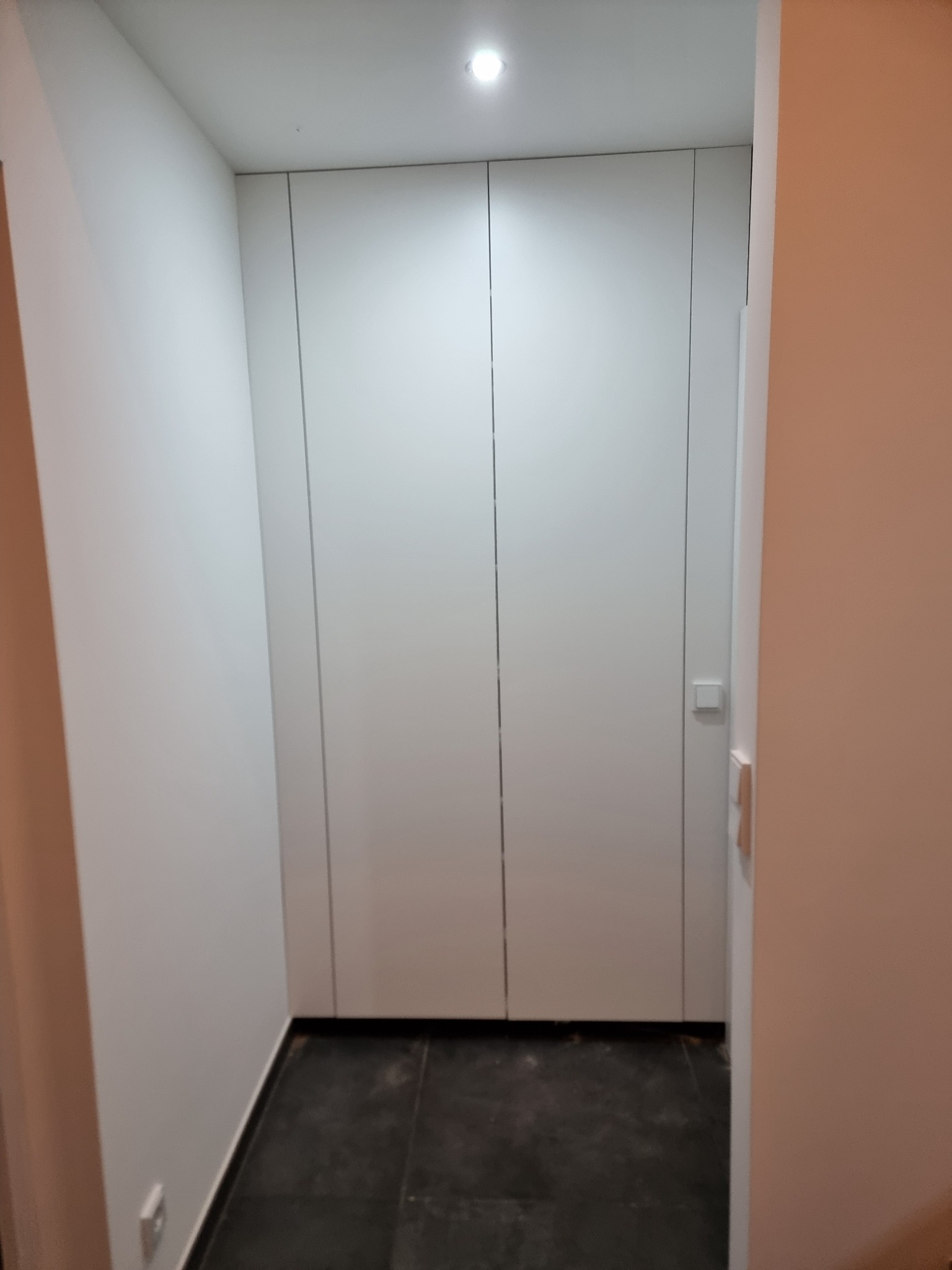 Deckenhoher maßgefertigter Einbauschrank in einer Mauernische