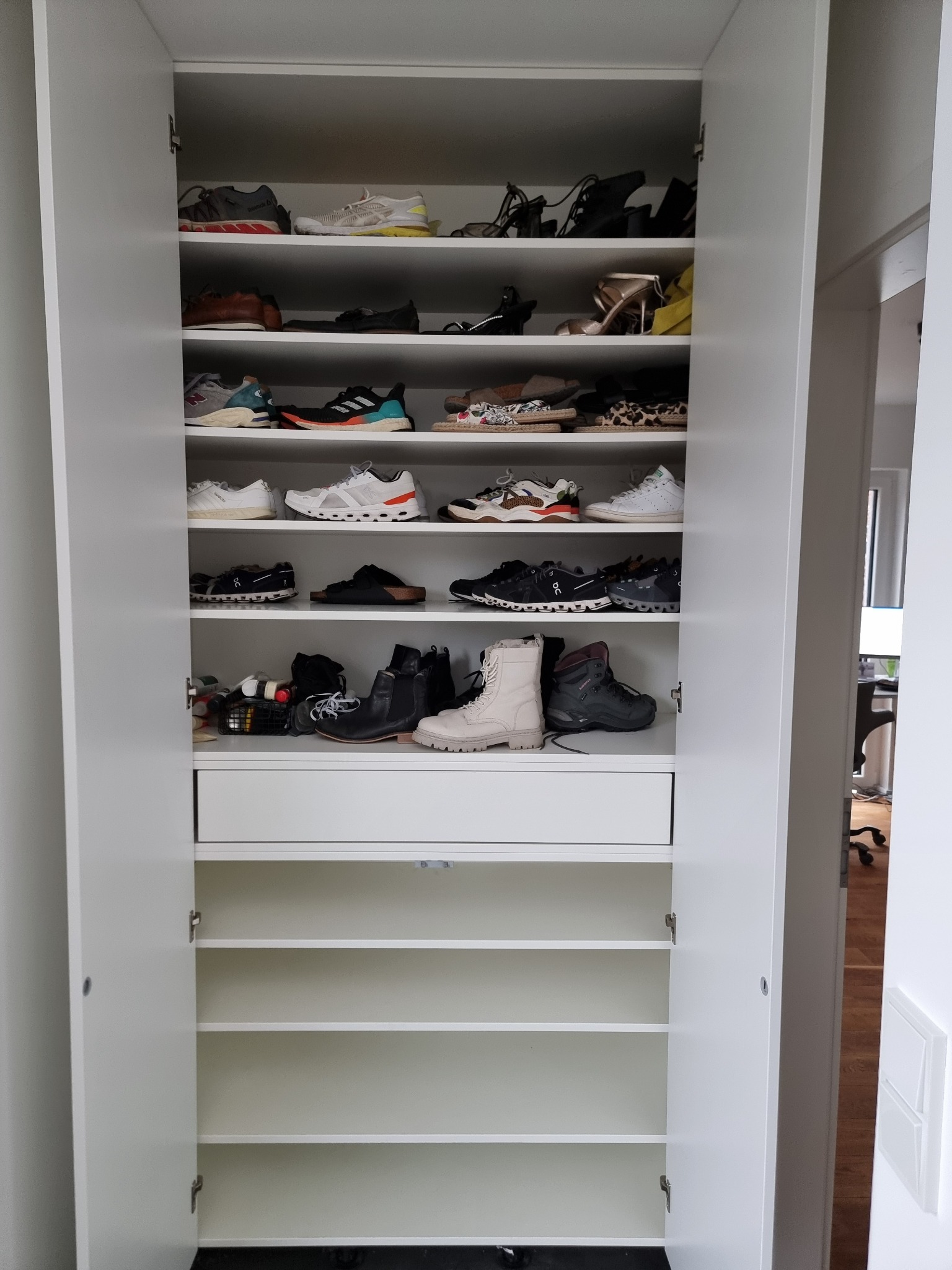 Geöffneter maßgefertigter Schuhschrank mit Fachböden und Schubladen